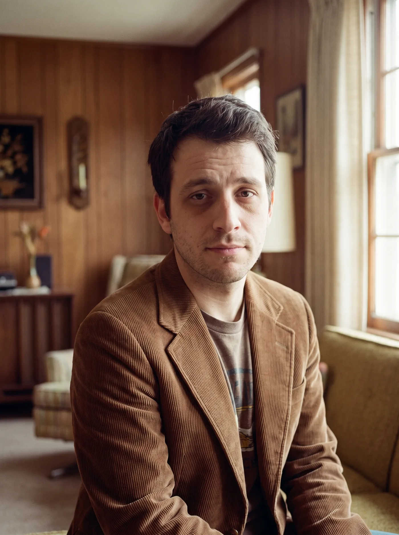 AI-edited 1970s film-style photo of the same man in a corduroy jacket in a mid-century room.