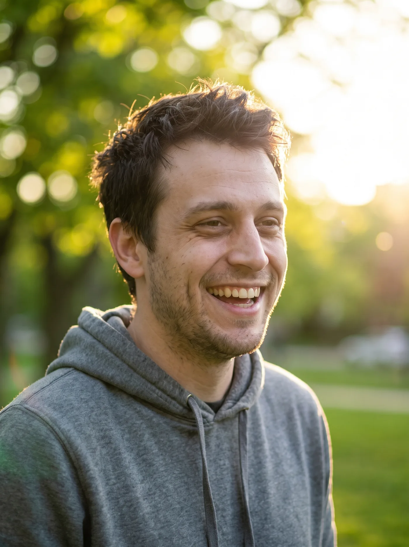 AI-edited golden hour portrait of the same man laughing in a park with warm backlight.
