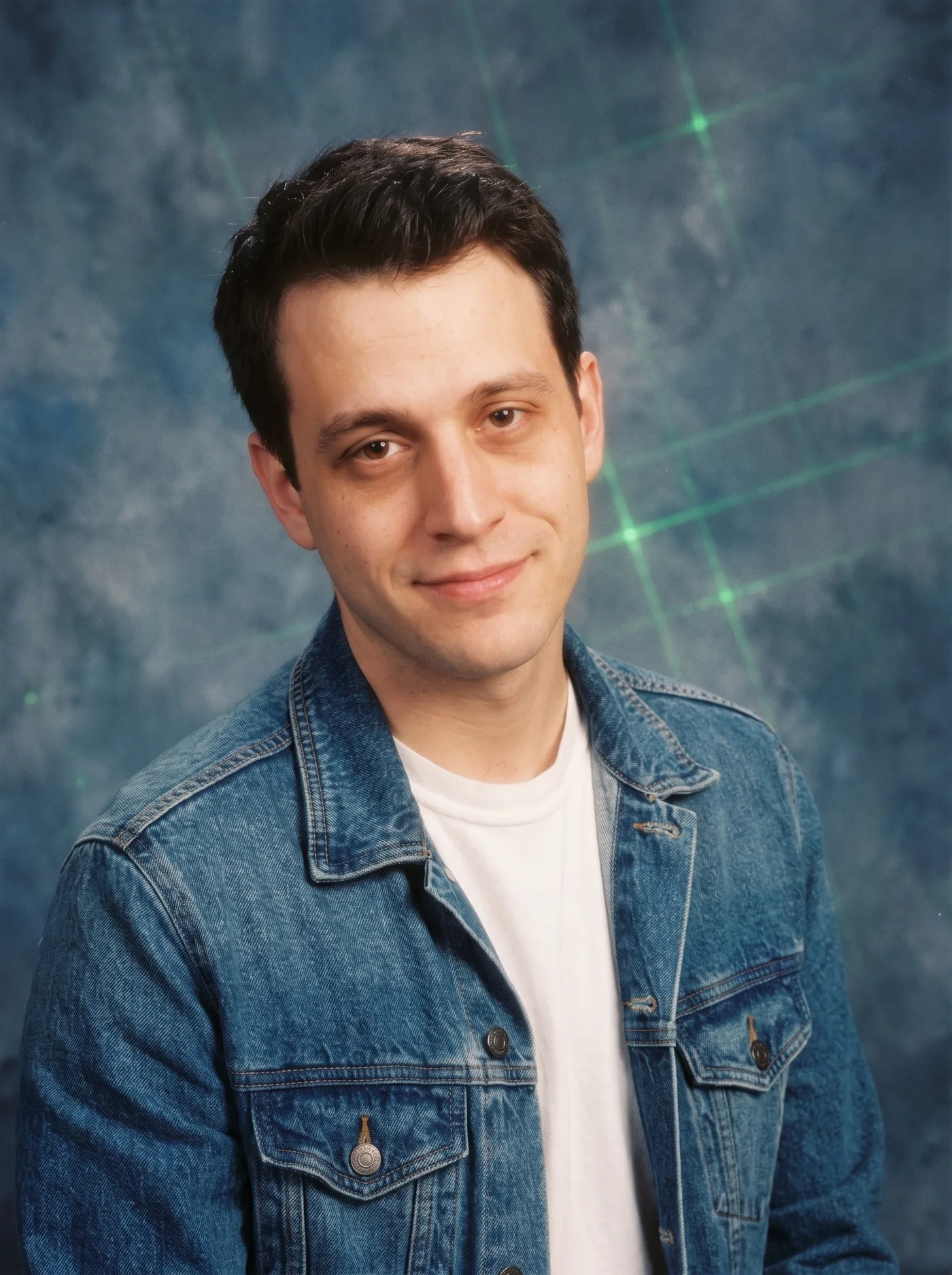 AI-edited 1990s studio-style portrait of the same man in a denim jacket against a laser-grid backdrop.