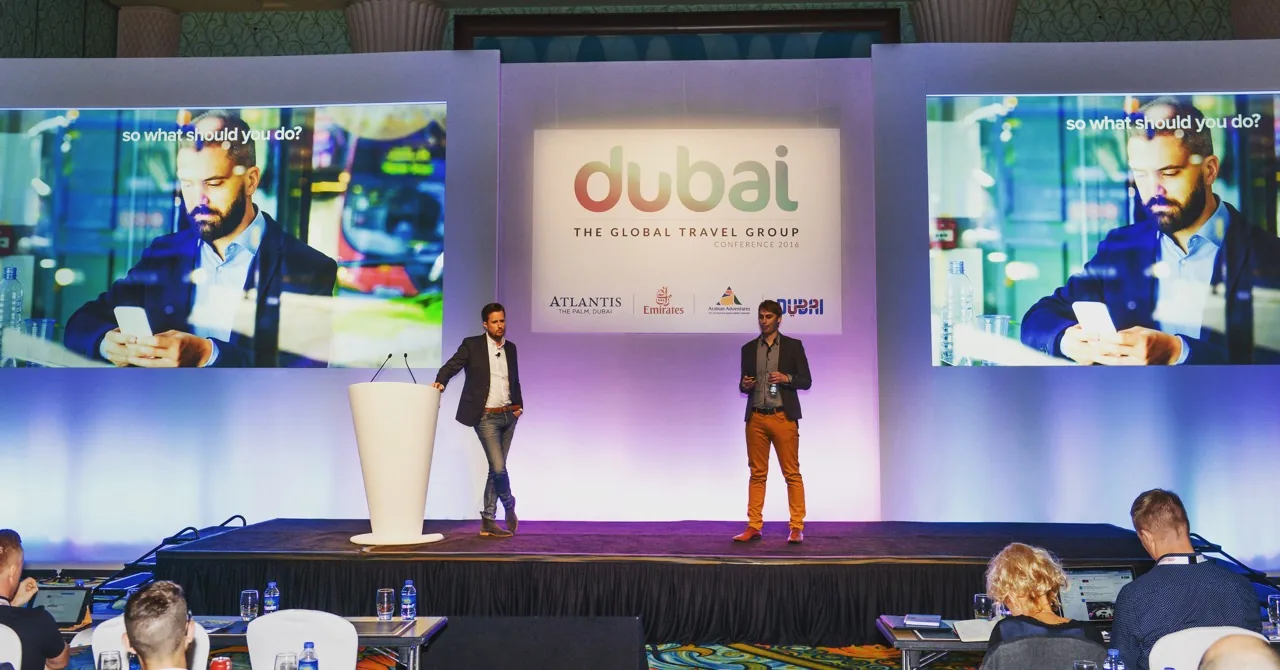 Two of the team presenting on stage at a conference in Dubai
