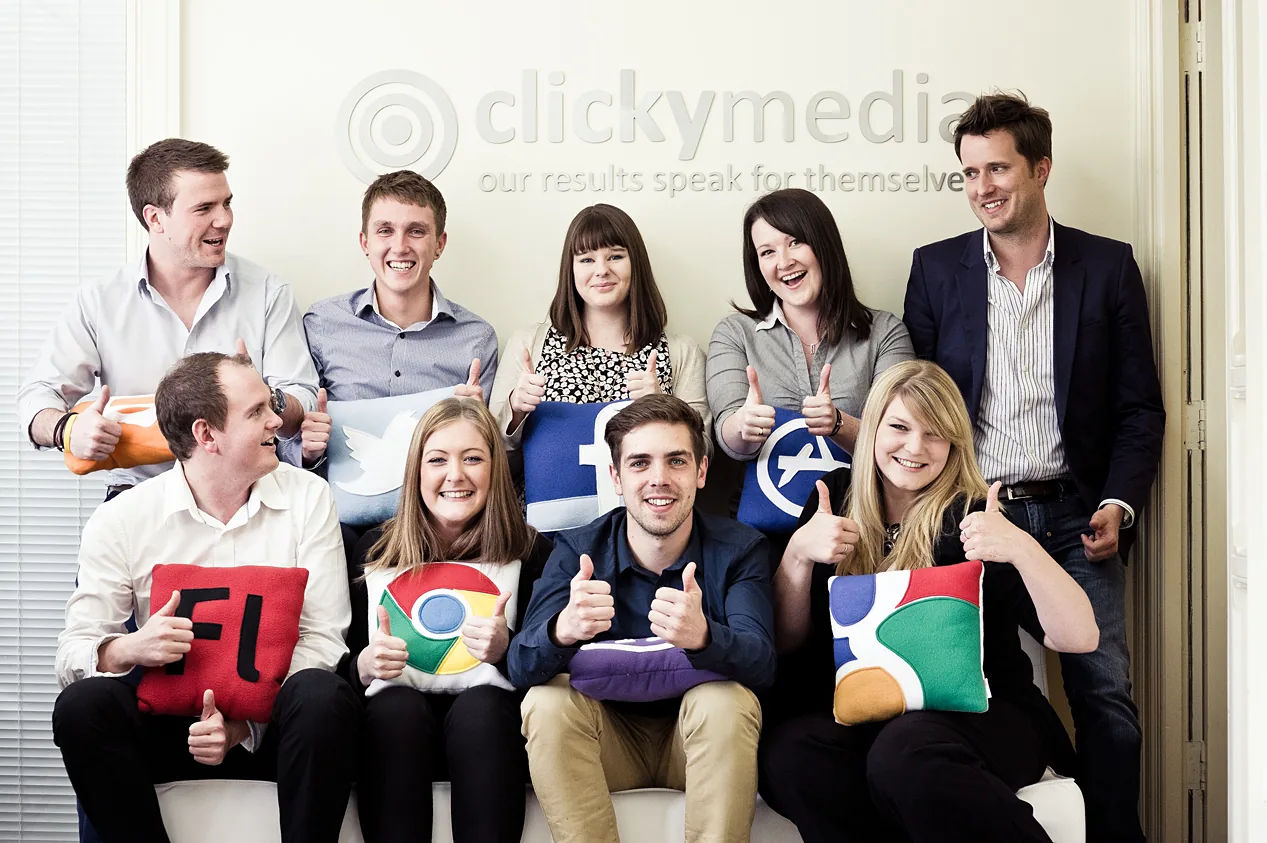 The Clicky Media team on the sofa giving thumbs up