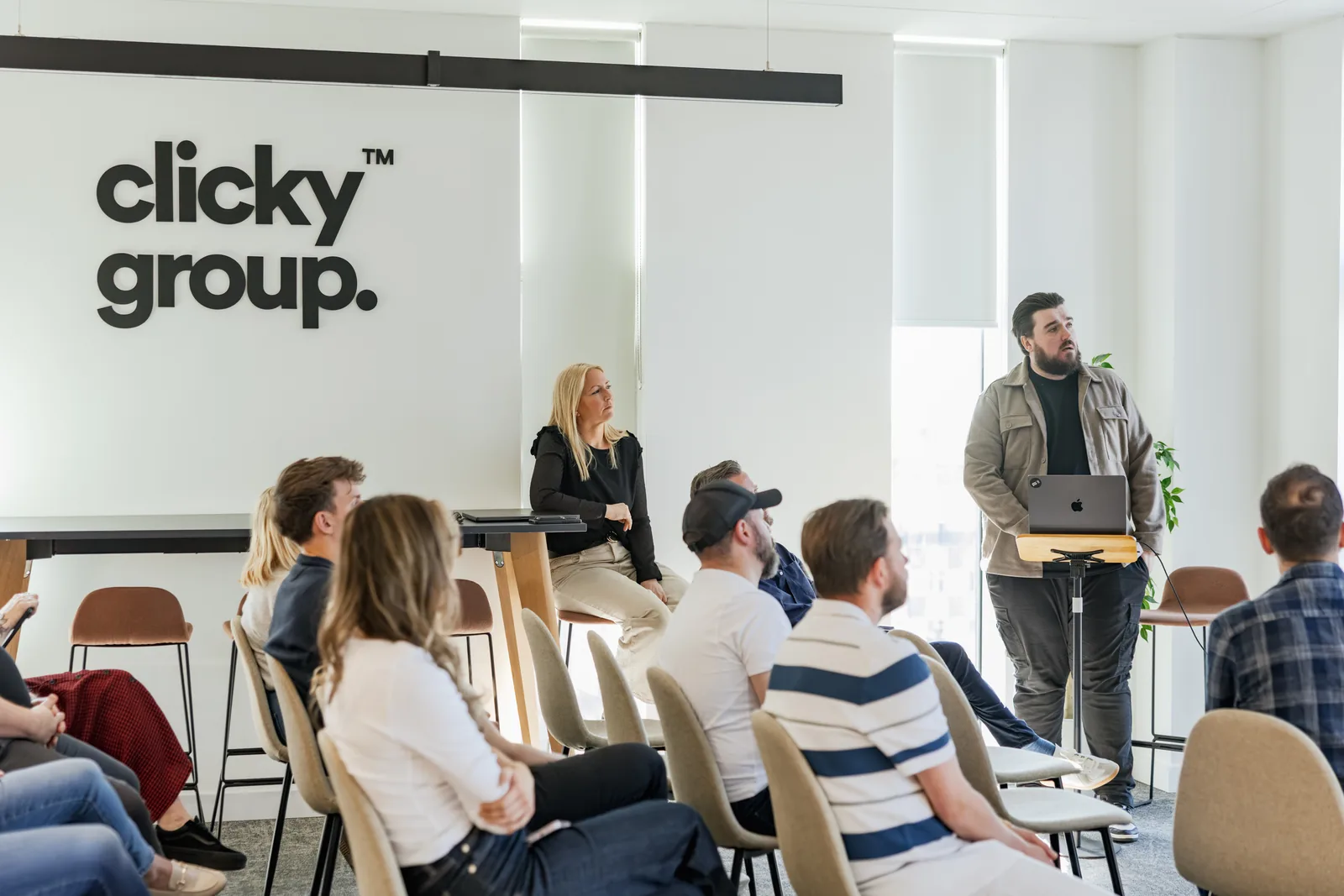 A presenter and the team at Agency Day under the Clicky Group logo
